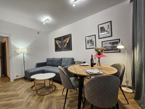 a living room with a table and a couch at Simply Apartament - Symfonia z parkingiem in Toruń