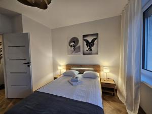 a bedroom with a bed and two lamps and a window at Simply Apartament - Symfonia z parkingiem in Toruń