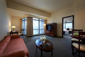 a living room with a couch and a television in a hotel room at The Times Square By Family Suites in Kuala Lumpur