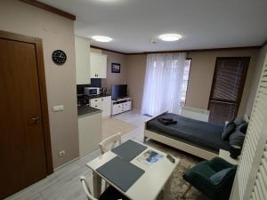 ein Wohnzimmer mit Couch und Tisch und eine Küche in der Unterkunft Four Seasons Apartment Bansko in Bansko + 30 Fotos