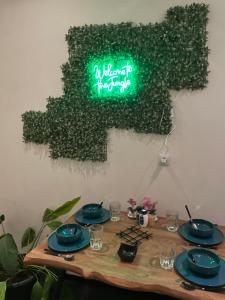 a table with plates and a neon sign on a wall at La Jungle Room in Troyes