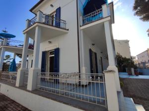 a white house with balconies on a street at Marina Azzurra VistaMare - HiTuscany in Marina di Campo +92 photos