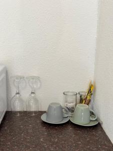 a table with glasses and plates and cups on it at The Herby Taylor Guest House in Vereeniging