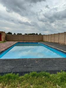 Una gran piscina azul en un patio. en The Herby Taylor Guest House, en Vereeniging