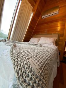 a large bed in a room with a window at Cabana Santo Rancho Treze Tílias in Treze Tílias