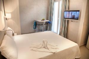 a room with a bed with a towel on it at Hotel Britannia Rimini Marina centro in Rimini