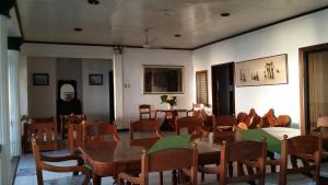 a dining room with tables and chairs and a man wearing a mask at Brazaville Beach Resort in Hinoba-an
