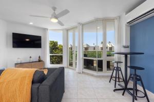 リオ・グランデにあるBalcony With Views Nice Pool Beach Accessのソファと大きな窓のあるリビングルーム