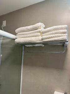a stack of towels on a towel rack in a bathroom at Studio no Centro de Floripa 200m da Beira Mar in Florianópolis +24 photos