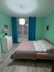 a bedroom with a bed with blue walls and a window at DAR-KAJ MIESZKANIE nr 4 in Grudziądz