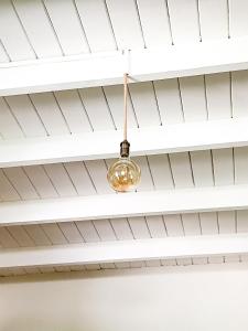 a light hanging from the ceiling of a room at Acogedora casa cerca de la Laguna, con pileta in Chascomús