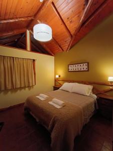 a bedroom with a bed with two towels on it at Aldea Aliwen in Trevelín +43 photos