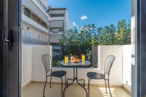 a balcony with a table and chairs and a window at Fly & Stay in Artemida