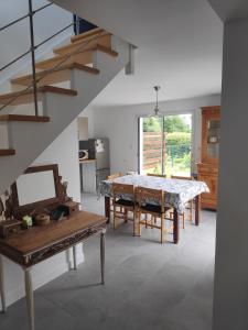a dining room with a table and a staircase at Maison bourg Muzillac 3 Chambres in Muzillac