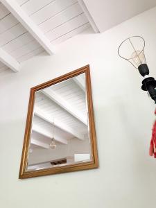 a mirror on the wall next to a light at Acogedora casa cerca de la Laguna, con pileta in Chascomús +67 photos