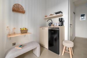 a small kitchen with a black refrigerator and a stool at Fly & Stay in Artemida +43 photos