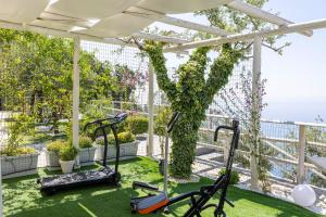 a fitness room with exercise equipment on a balcony at Villa Cimea in Furore