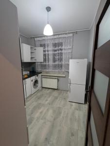 a small kitchen with a refrigerator and a window at DAR-KAJ MIESZKANIE nr 4 in Grudziądz +27 photos