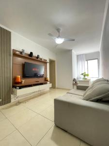 sypialnia z łóżkiem i telewizorem z płaskim ekranem w obiekcie Brilho do mar Enseada w mieście Guarujá