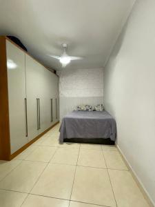 pokój z łóżkiem w rogu pokoju w obiekcie Brilho do mar Enseada w mieście Guarujá