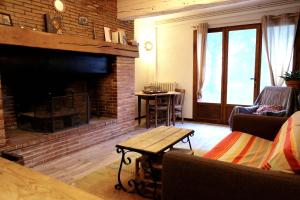 a living room with a brick fireplace and a table at maison campagne jardin in Giroussens