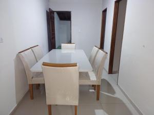 a white table and chairs in a room at Casa no centro de Japaratinga in Japaratinga
