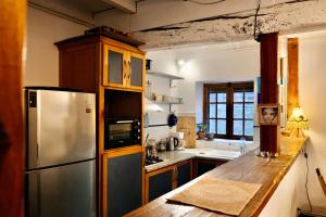 a kitchen with a stainless steel refrigerator and a counter at maison campagne jardin in Giroussens