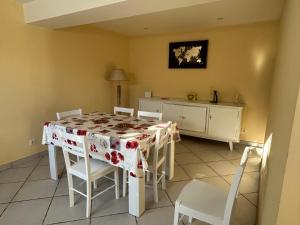 a dining room with a table and white chairs at Gîte de la Pastorale in Moirans