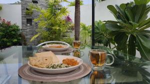 a glass table with a plate of food and drinks at Vaadhoo View Inn in Wadu