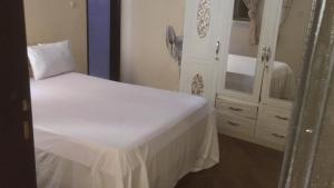 a bedroom with a white bed and a dresser at darou salam house in Rufisque