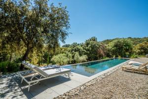 a pool with a slide and two chairs next to it at Expériences Les Chênes Verts - Gîtes de charme in Piolenc