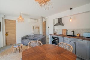 a kitchen and living room with a table and a couch at Expériences Les Chênes Verts - Gîtes de charme in Piolenc