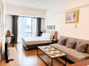 a living room with a couch and a bed at Abreeza Place Cozy Condo in Davao City