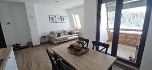 a living room with a table and a couch at Apartment Holiday Ravna Planina in Pale