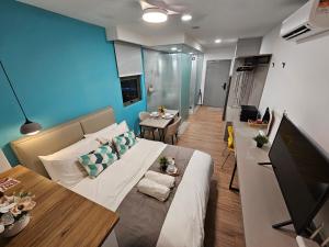 a living room with a large bed and a table at SerenityStayatRiveria KL Sentral in Kuala Lumpur