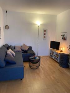 a living room with a blue couch and a television at Ferienwohnung am Salmtalradweg Region Eifel Mosel in Sehlem