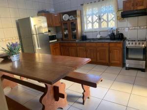 a kitchen with a wooden table and a refrigerator at Casa espaçosa a 300m do mar in Piçarras