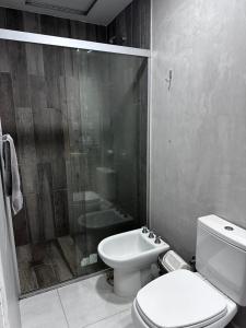 a bathroom with a toilet and a shower and a sink at Edificio Victoria in Encarnación