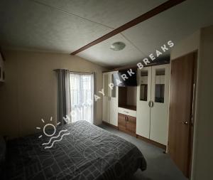 a bedroom with a bed and a sign that reads emergency at Goldfinch - Spacious 2 bed at Seal Bay in Selsey +20 photos