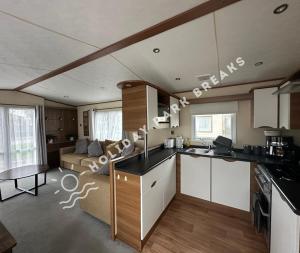 a kitchen and a living room with a couch at Goldfinch - Spacious 2 bed at Seal Bay in Selsey