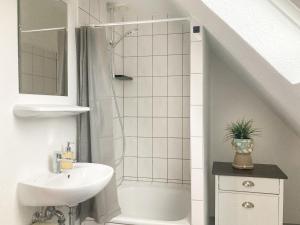 a white bathroom with a sink and a shower at PEARLs - Gemütliches Dachgeschoss-Studio im Zentrum von Kleve in Kleve