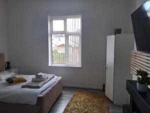 a white room with a bed and a window at Zak Air B&B Stay 9 people's in Birmingham