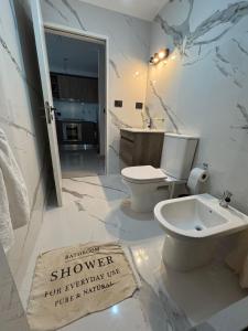 Un baño blanco con lavabo e inodoro. en Valdés House, en Puerto Madryn 4 fotos más
