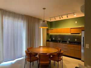 a kitchen with a table and chairs in a kitchen at Cobertura pôr-do-sól com jacuzzi in Bombinhas
