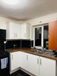 a kitchen with white cabinets and a sink at CityZen - serviced accomodation in Birmingham +29 photos