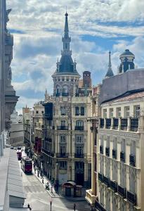a large building with a tower on top of a street at Piso Ático con Terraza y Jacuzzi con vistas a Sol en Madrid Centro in Madrid