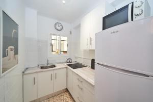 eine weiße Küche mit Spüle und Kühlschrank in der Unterkunft Cielo Azul in Nerja