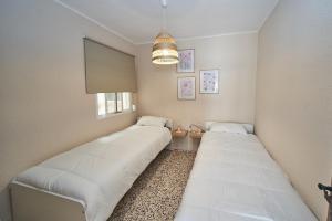 zwei Betten in einem kleinen Zimmer mit Fenster in der Unterkunft Cielo Azul in Nerja