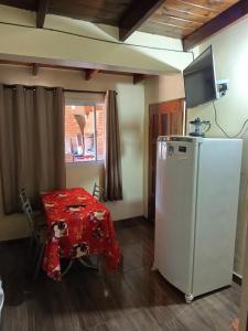 a small kitchen with a table and a refrigerator at Apart la hermosa in Puerto Iguazú