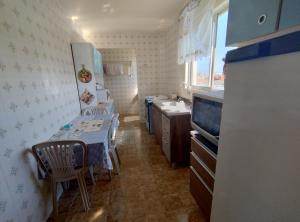 a small kitchen with a table and a sink and a counter at AP de Itapirubá in Imbituba